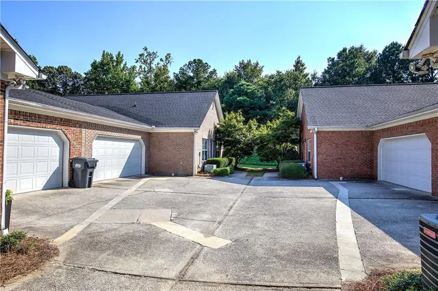 a view of house with outdoor space and trees in the background