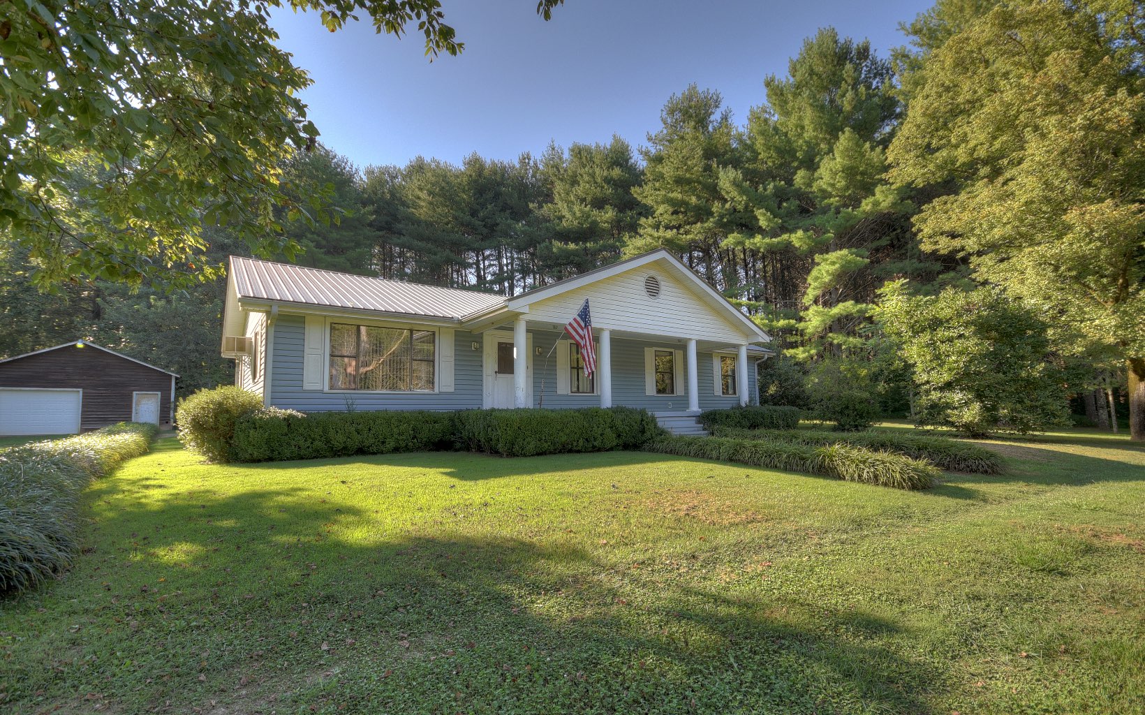 a front view of a house with yard and green space