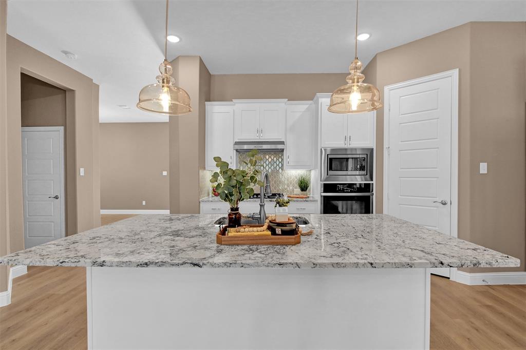 a kitchen with kitchen island granite countertop a sink cabinets and refrigerator