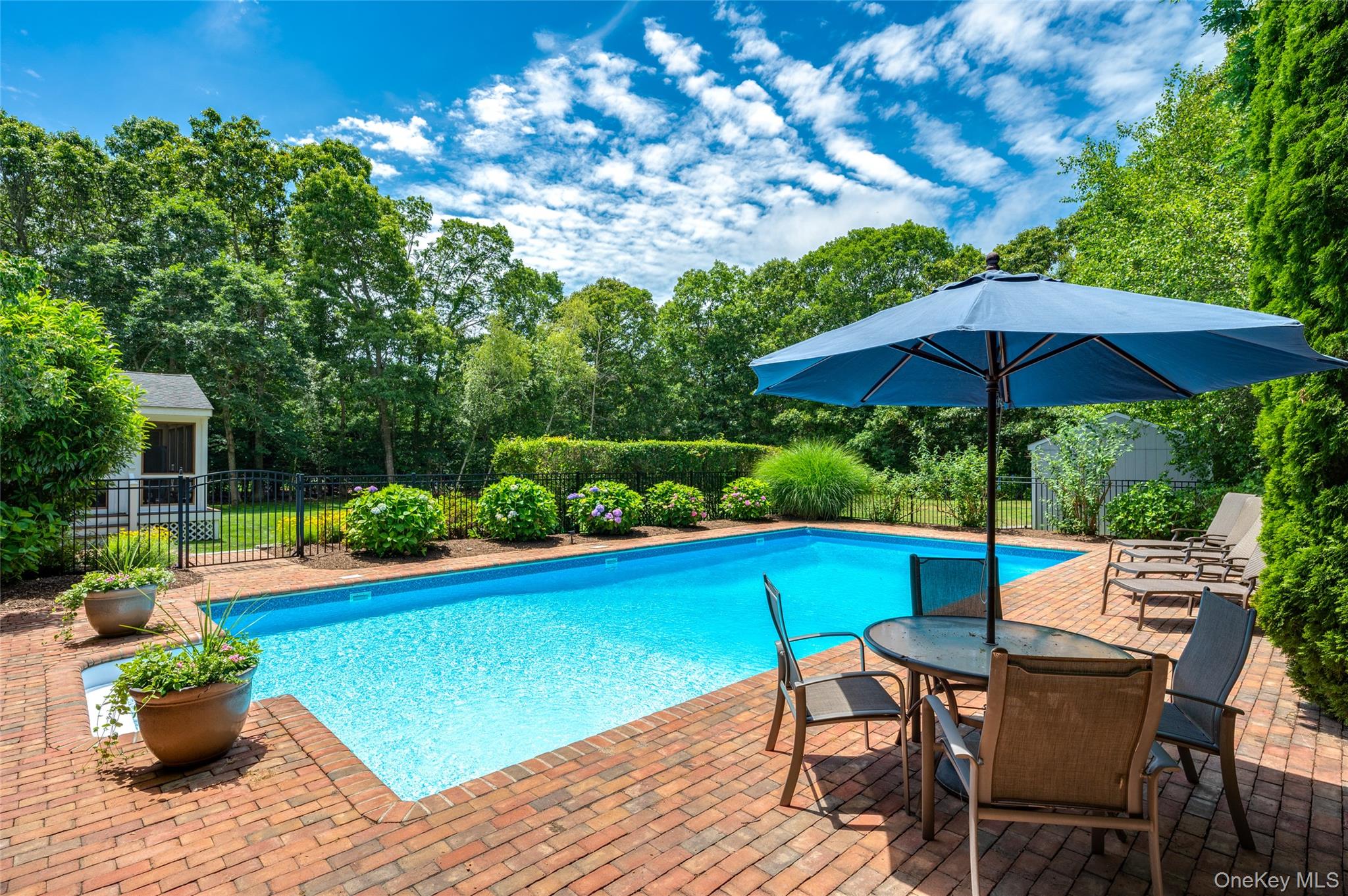 9 North Quarter Road Westhampton, NY 11977 - Photo 29 of 38 a view of a chairs and table under an umbrella in backyard
