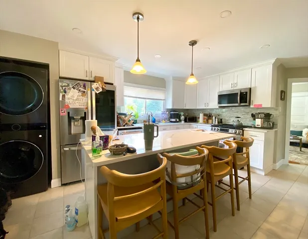a kitchen with stainless steel appliances granite countertop a sink a stove and a wooden floors