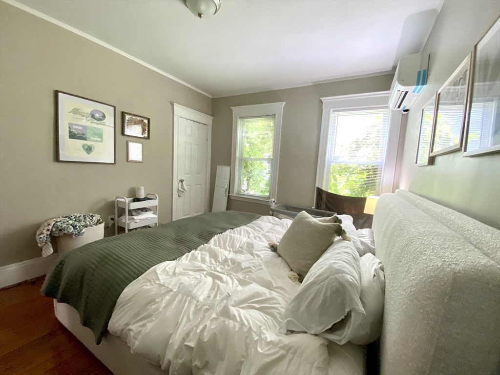 1011 Washington Street, Unit 1 Newton, MA 02460 - Photo 13 of 17 a bedroom with a bed and wooden floor