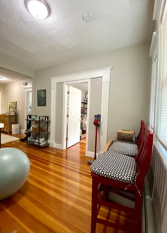 a living room with furniture a wooden floor and next to a window