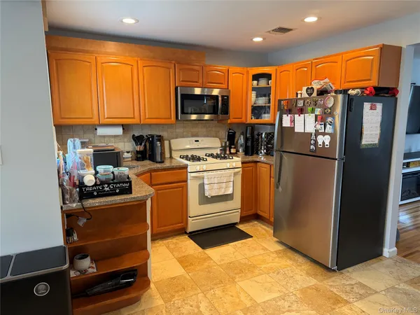 a kitchen with stainless steel appliances granite countertop a refrigerator and a stove top oven