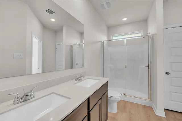a bathroom with a bathtub shower sink vanity and toilet