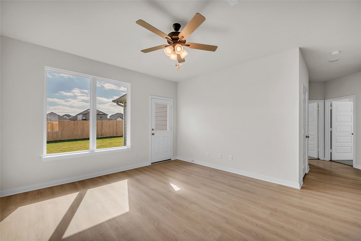 308 Boatright Boulevard Jarrell, TX 76537 - Photo 22 of 31 an empty room with wooden floor fan and windows