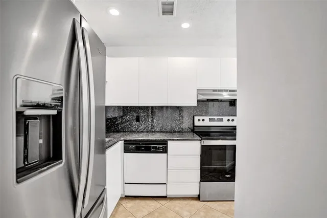 a kitchen with stainless steel appliances kitchen island granite countertop a stove and a sink