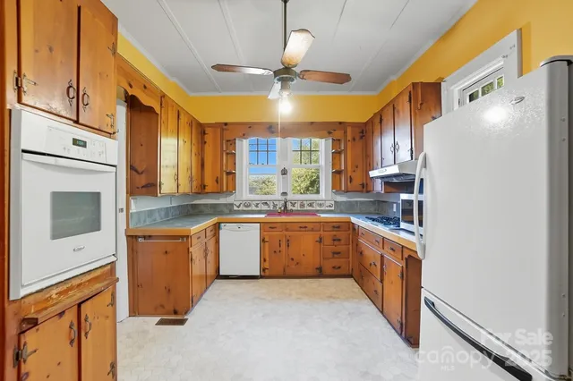 a kitchen with granite countertop a sink stainless steel appliances and cabinets