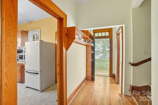 a view of a hallway with entryway and wooden floor