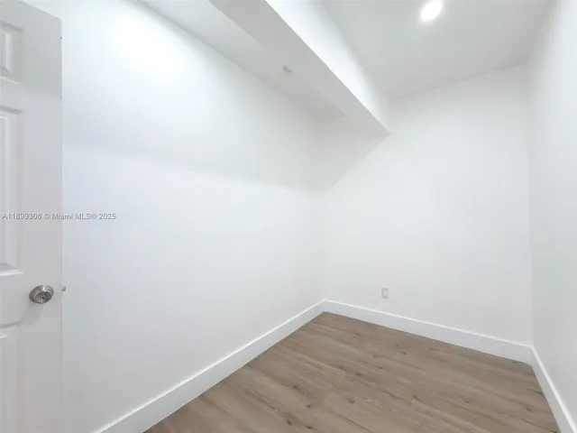 a kitchen with a refrigerator a sink and wooden floor