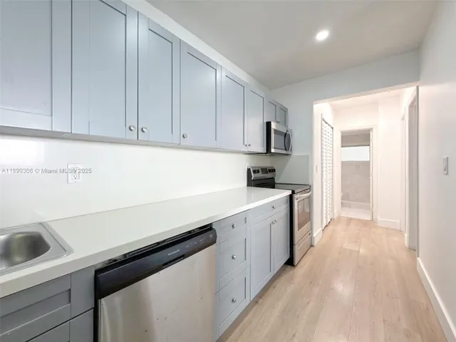 a kitchen with a sink cabinets and stainless steel appliances