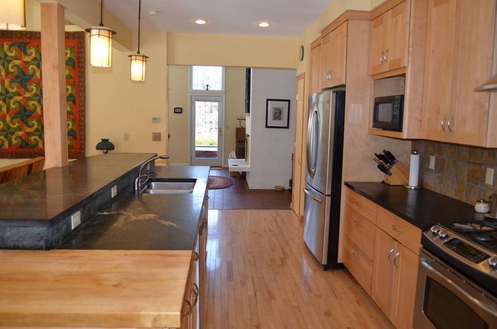 48 Meetinghouse Road Pelham, MA 01002 - Photo 15 of 30 a kitchen with stainless steel appliances granite countertop a refrigerator a stove and a wooden floors