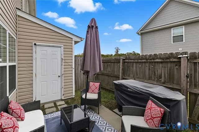 a backyard of a house with barbeque oven table and chairs