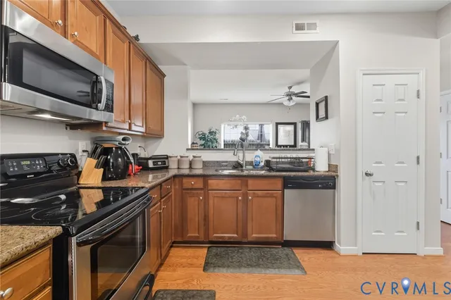 a kitchen with stainless steel appliances granite countertop a stove a sink and a microwave