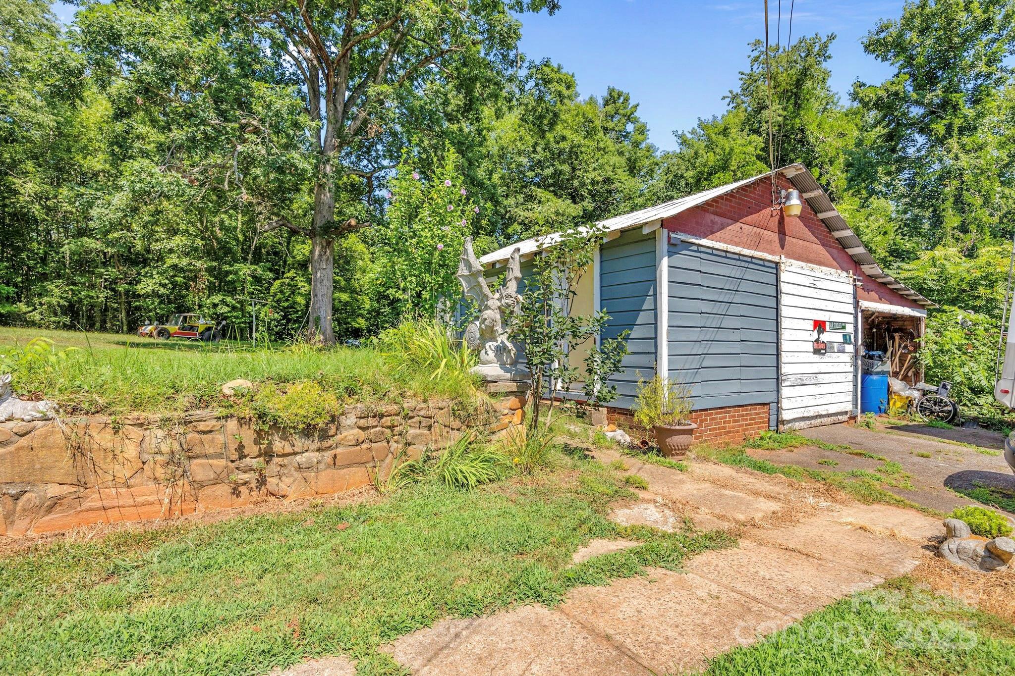 2401 Highway 181 Morganton, NC 28655 - Photo 15 of 17 a backyard of a house with table and chairs plants and large trees