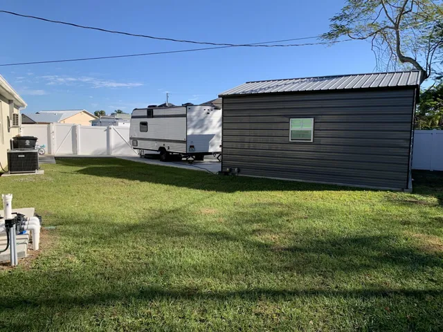 a view of a backyard with plants and a chair
