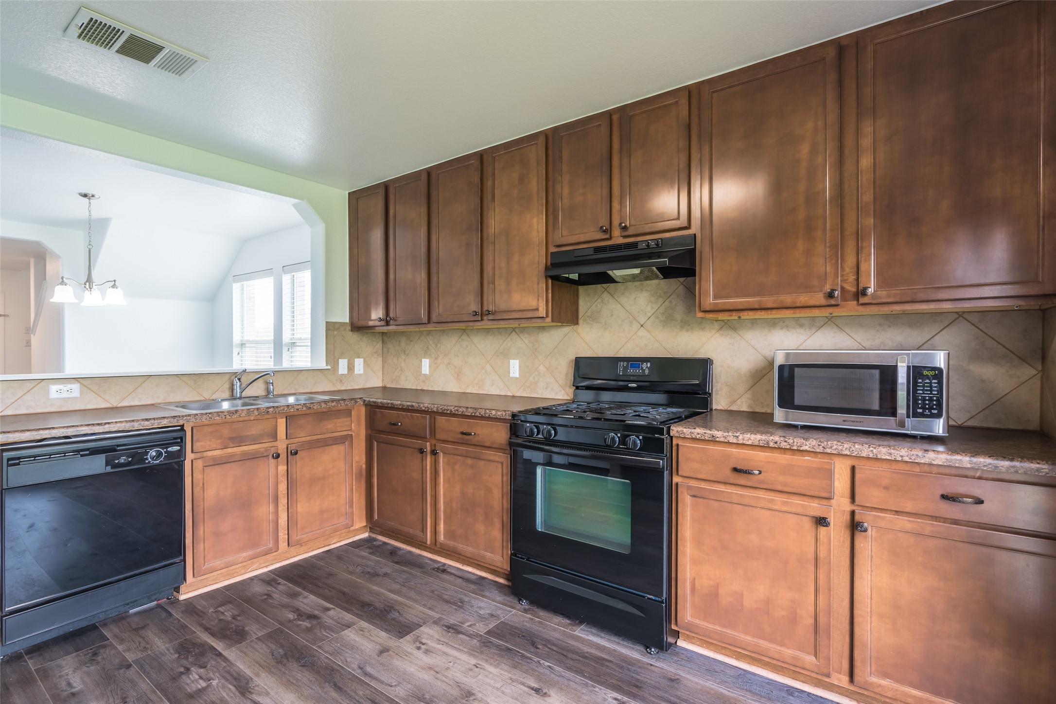 1013 Ranchero Road Leander, TX 78641 - Photo 4 of 30 Rich wood cabinetry and ample counter space define this functional culinary workspace.