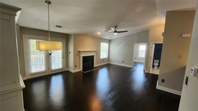 a view of empty room with wooden floor and fireplace