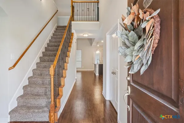 a view of staircase with white walls and wooden floor