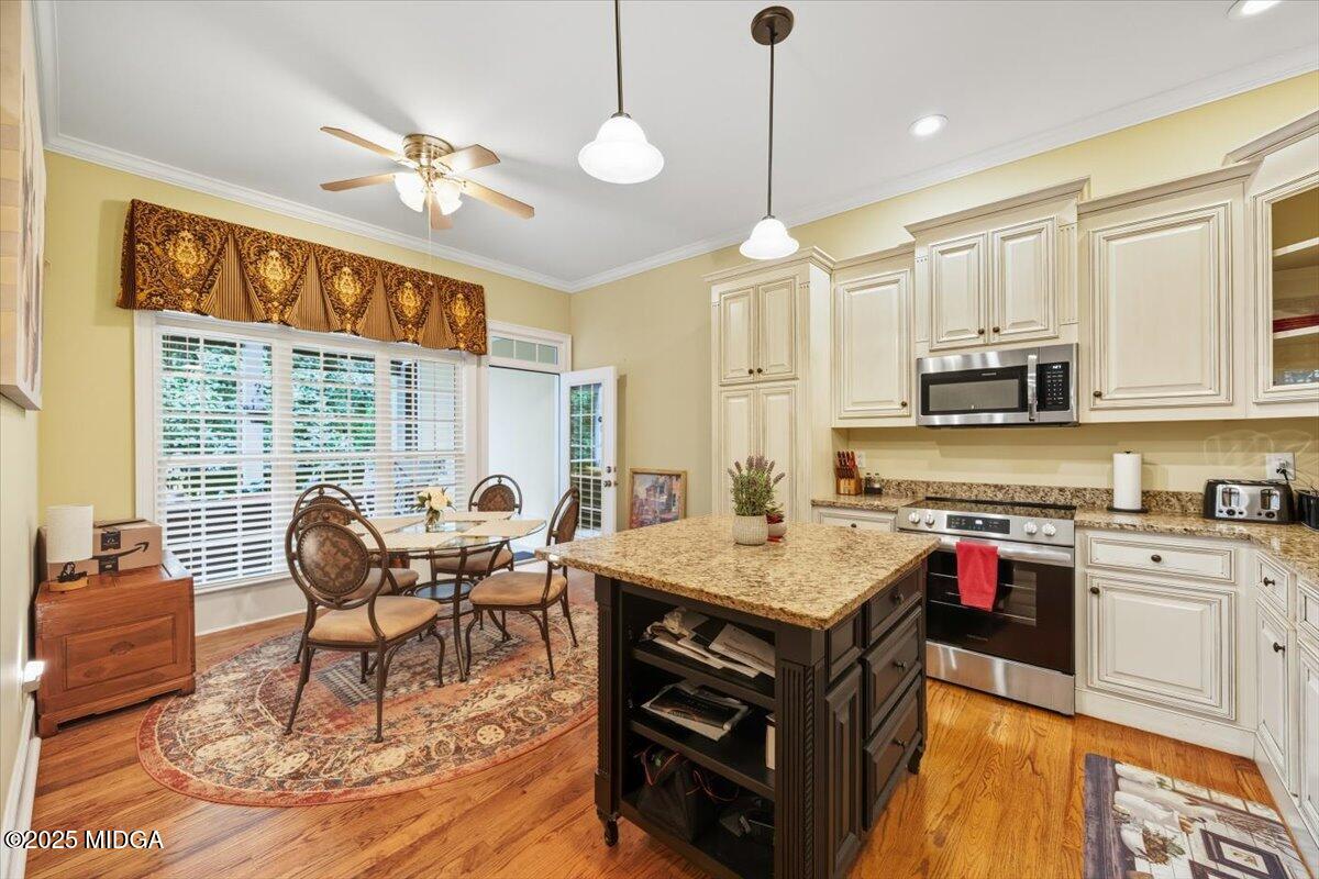 855 Tufthunter Macon, GA 31210 - Photo 17 of 38 a open kitchen with stainless steel appliances granite countertop a stove top oven a dining table and chairs with wooden floor