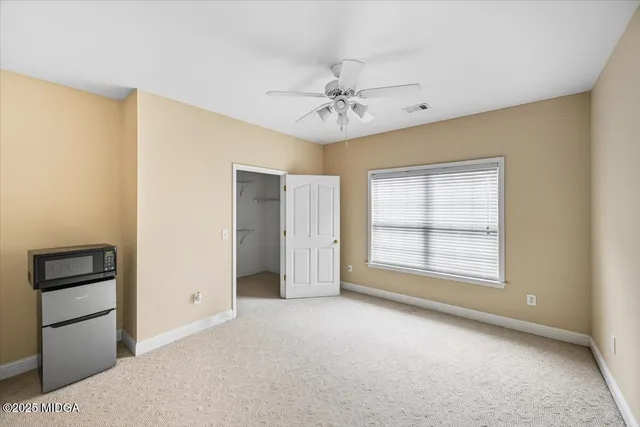 a view of a room with a ceiling fan and entryway