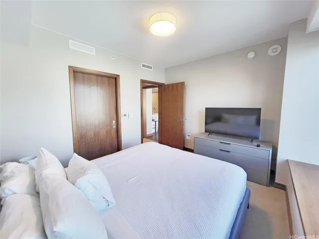 a bedroom with a bed and a flat screen tv