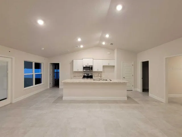 a view of kitchen with refrigerator and window