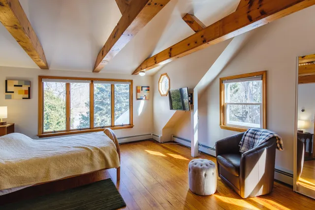 a bedroom with furniture and a large window