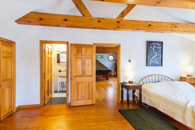 a spacious bedroom with a bed and wooden floor