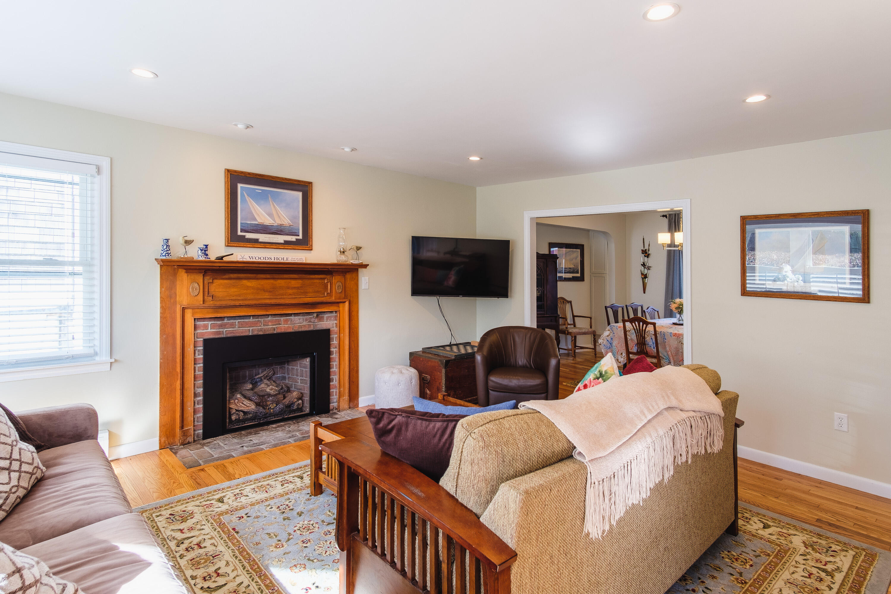 2 Huettner Road Woods Hole, MA 02543 - Photo 2 of 20 a living room with furniture a flat screen tv and a fireplace