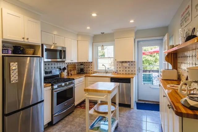 a kitchen with stainless steel appliances granite countertop a stove refrigerator sink and microwave