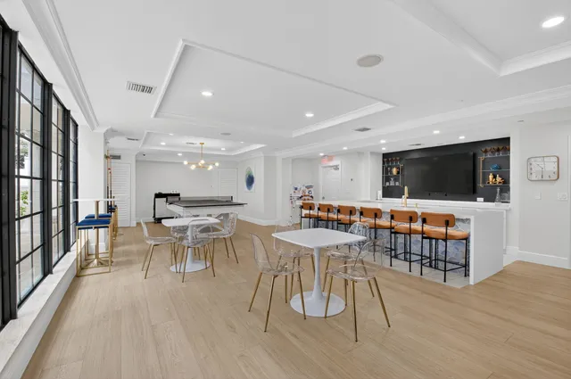 a room with lots of furniture and view of kitchen