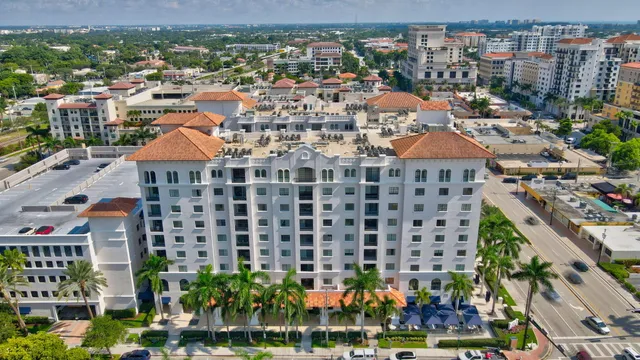 a view of a multi story residential apartment building with a yard