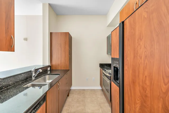 a kitchen with granite countertop a sink stove and refrigerator
