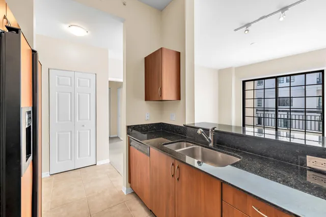 a kitchen with granite countertop a sink and a refrigerator