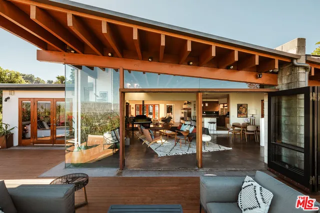 a view of a patio with table and chairs potted plants with wooden floor and fence