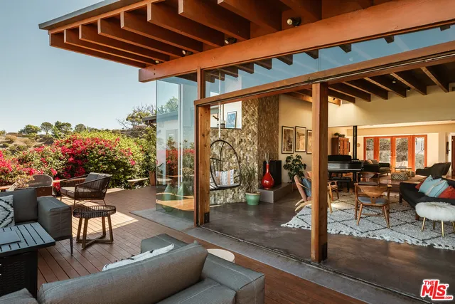 a view of a patio with table and chairs potted plants with wooden floor and seating space