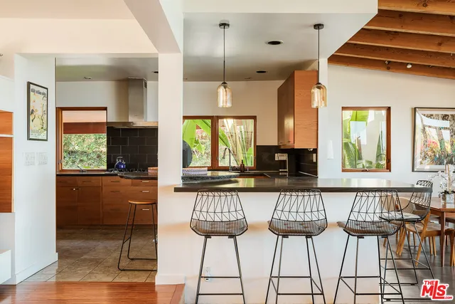 a kitchen with stainless steel appliances a dining table chairs and chandelier