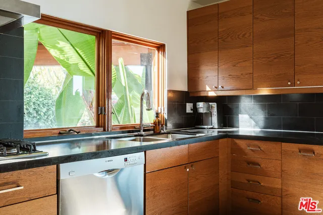 a kitchen with a window sink and cabinets