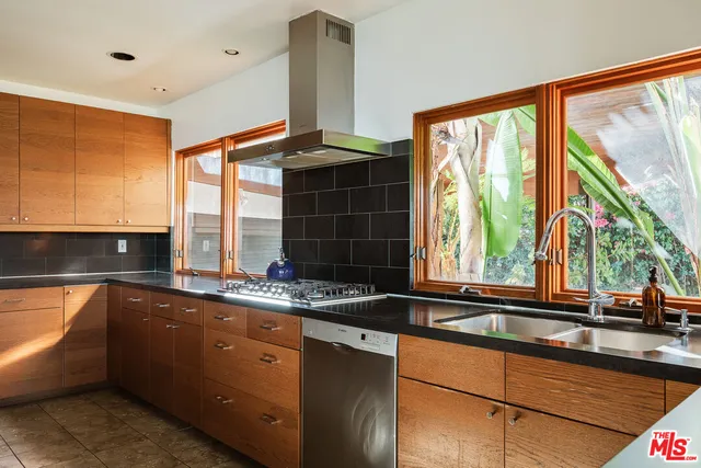 a kitchen with stainless steel appliances granite countertop a refrigerator and a stove