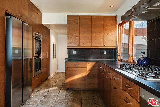 a kitchen with stainless steel appliances granite countertop a refrigerator and a stove