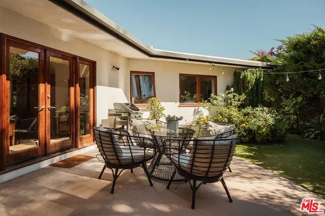 a view of a house with backyard sitting area and garden