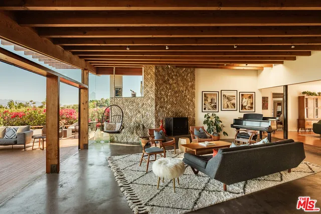 a living room with fireplace furniture and a large window