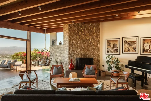 a living room with furniture and a floor to ceiling window