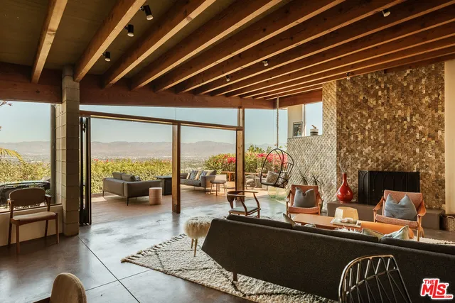 a living room with fireplace furniture and a large window