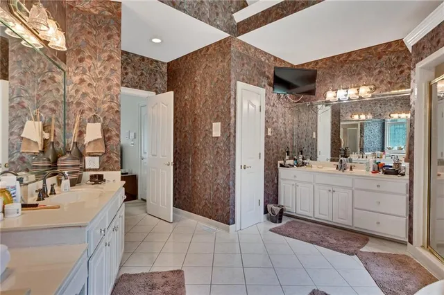 a large bathroom with a double vanity sink a large mirror and shower