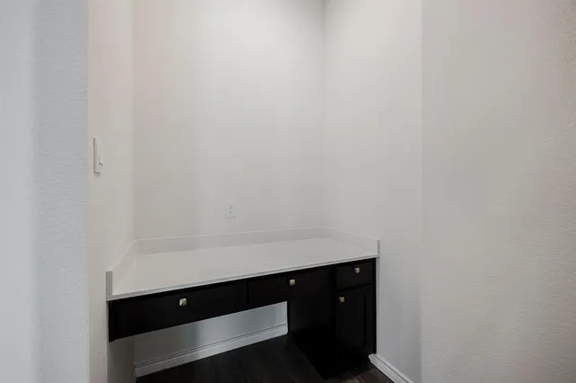 an empty room with wooden floor ceiling fan and window