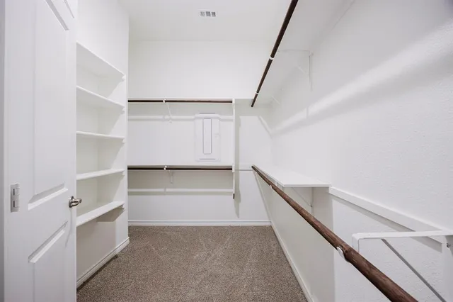 a view of walk in closet with empty racks