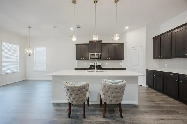 a large kitchen with kitchen island a sink table and chairs