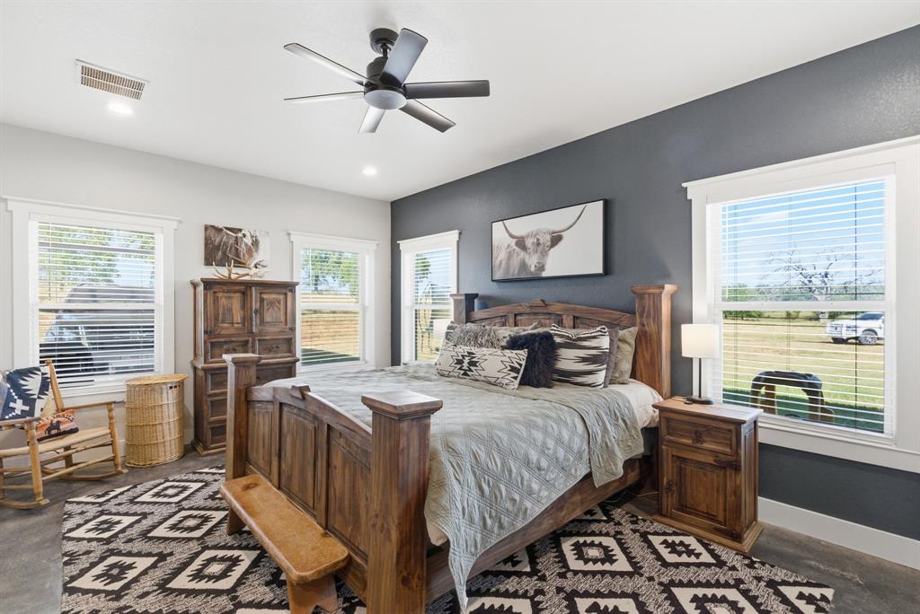 1734 Davis Road Lipan, TX 76462 - Photo 11 of 40 a bedroom with a bed next to a window with a dining table